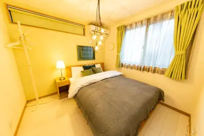 a bedroom with a bed and a chandelier at Y's HOTEL KAMEARI in Tokyo