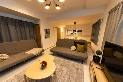 a living room with a couch and a table at Y's HOTEL KAMEARI in Tokyo