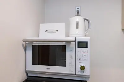 a microwave with a kettle on top of it at Y's HOTEL KAMEARI in Tokyo