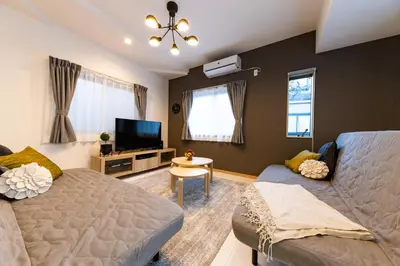 a living room with a bed and a flat screen tv at Y's HOTEL KAMEARI in Tokyo