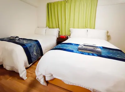 a room with two beds and a green window at Rosenheim Tokyo Shinjuku in Tokyo