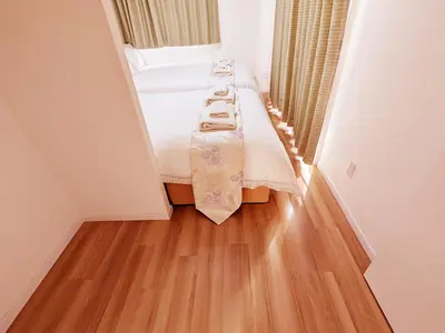 a small room with a bed and a wooden floor at Rosenheim Tokyo Shinjuku in Tokyo