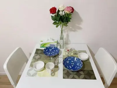 a table with blue and white plates and a vase with roses at Rosenheim Tokyo Shinjuku in Tokyo