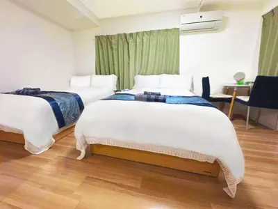 a hotel room with two beds and a desk at Rosenheim Tokyo Shinjuku in Tokyo