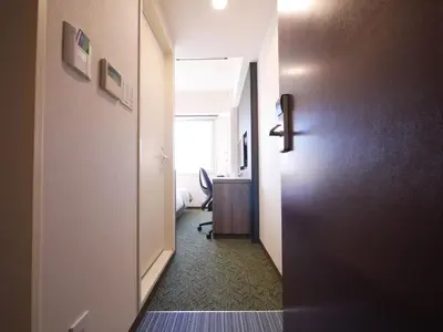 a hallway with a door to a room with a desk at Hotel Comfybed Ginza in Tokyo