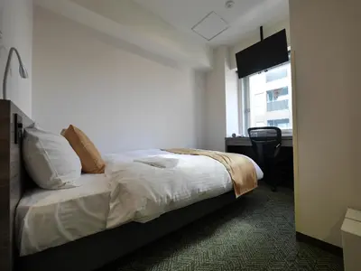a hotel room with a bed and a window at Hotel Comfybed Ginza in Tokyo