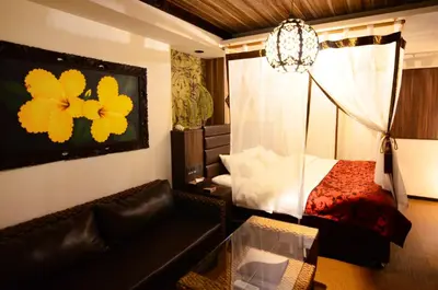 a living room with a bed and a couch in a room at Hotel BaliBali ANNEX \u4e94\u53cd\u7530 in Tokyo