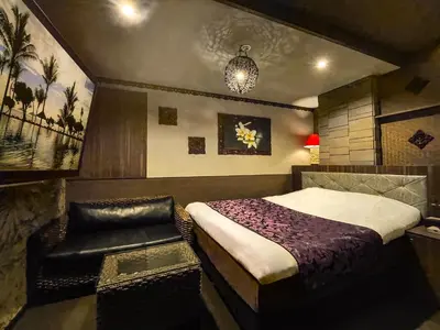 a bedroom with a bed and a chair in it at Hotel BaliBali ANNEX \u4e94\u53cd\u7530 in Tokyo