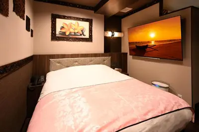 a bedroom with a bed and a painting on the wall at Hotel BaliBali ANNEX \u4e94\u53cd\u7530 in Tokyo