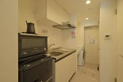 a small kitchen with a sink and a stove at Hotel FANDINA TOKYO -\u30d5\u30a1\u30f3\u30c7\u30a3\u30fc\u30ca\u6771\u4eac- in Tokyo