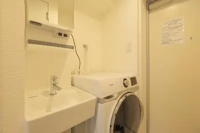 a bathroom with a washing machine and a sink at Hotel FANDINA TOKYO -\u30d5\u30a1\u30f3\u30c7\u30a3\u30fc\u30ca\u6771\u4eac- in Tokyo
