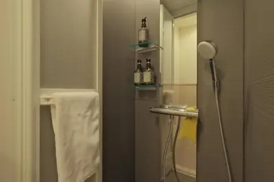 a bathroom with a shower with a sink and a mirror at Hotel FANDINA TOKYO -\u30d5\u30a1\u30f3\u30c7\u30a3\u30fc\u30ca\u6771\u4eac- in Tokyo
