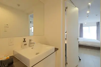 a white bathroom with a sink and a mirror at Hotel FANDINA TOKYO -\u30d5\u30a1\u30f3\u30c7\u30a3\u30fc\u30ca\u6771\u4eac- in Tokyo