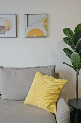 a gray couch with a yellow pillow in a living room at Hotel FANDINA TOKYO -\u30d5\u30a1\u30f3\u30c7\u30a3\u30fc\u30ca\u6771\u4eac- in Tokyo