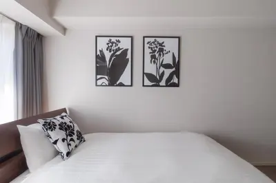 a white bedroom with three pictures on the wall at LANG HOTEL Kameido-2#Near Akihabara#\u30c1\u30a7\u30c3\u30af\u30a2\u30a6\u30c8\u306e\u307f\u6e05\u6383\u3042\u308a in Tokyo