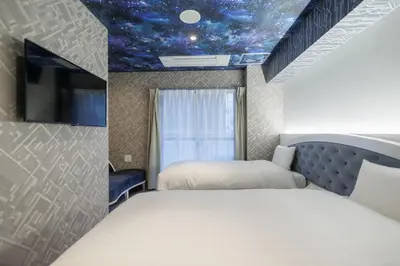 a bedroom with two beds and a ceiling with a star ceiling at Hotaku HOTEL Akihabara in Tokyo
