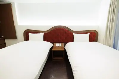 two beds in a hotel room with white sheets at Hotaku HOTEL Akihabara in Tokyo