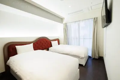 a hotel room with two beds and a television at Hotaku HOTEL Akihabara in Tokyo