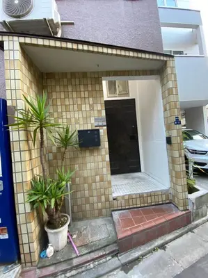 a small house with two plants in front of it at Takemura Building 2nd floor in Tokyo