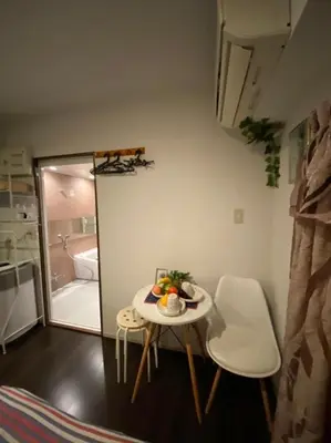 a small table and chairs in a room with a bath tub at Takemura Building 2nd floor in Tokyo