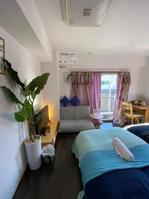 a bedroom with a bed and a couch in a room at Takemura Building 2nd floor in Tokyo