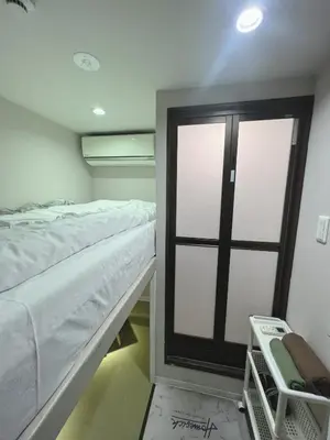 a room with a bed and a sliding glass door at \u8aa0\u5bb6\u3000MAKOTO HOSTEL in Tokyo