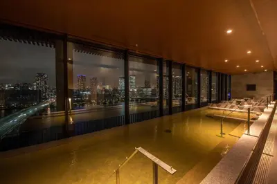 a building with a pool with a view of the city at La Vista Tokyo Bay in Tokyo