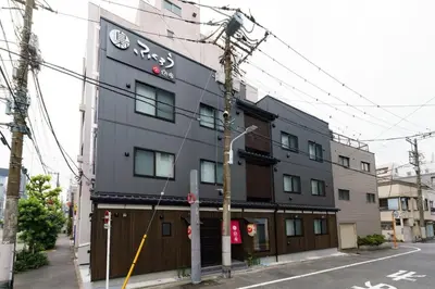 a black building with a sign on the side of it at YADOYA Fukurou in Tokyo