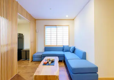 a living room with a blue couch and a table at YADOYA Suzume in Tokyo