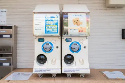two washing machines sitting next to a wall at E JOY INN-Okubo branch in Tokyo