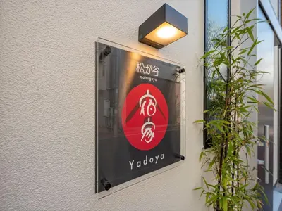 a sign on the side of a building with a light at YADOYA Matsugaya in Tokyo