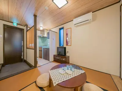 a living room with a table and chairs and a television at YADOYA Matsugaya in Tokyo