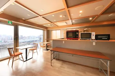 a room with a table and chairs and a kitchen at Tamayura Hotel Asakusa in Tokyo