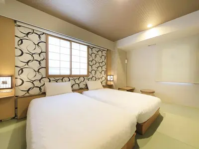 a bedroom with two beds and a window at Tamayura Hotel Asakusa in Tokyo