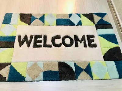 a sign with the word welcome on a rug at Guest house \u83ef\u97f3 in Tokyo