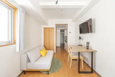 a living room with a white couch and a desk at Dash Living Shinjuku in Tokyo