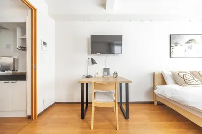 a bedroom with a desk and a bed and a bed and a bed at Dash Living Shinjuku in Tokyo