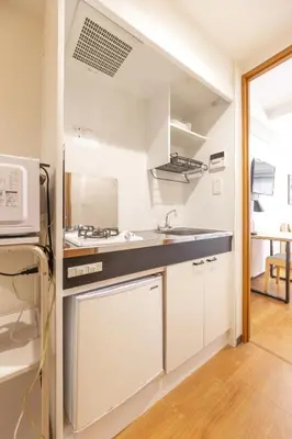 a kitchen with a sink and a microwave at Dash Living Shinjuku in Tokyo