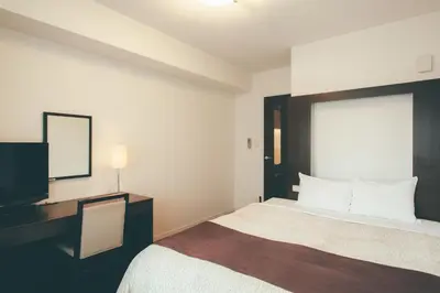 a hotel room with a bed and a flat screen tv at Kuretake Inn Premium Hamamatsucho in Tokyo
