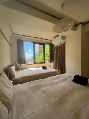 two beds in a room with a window at \u56db\u8c37\u677e\u672c\u9928\u30d3\u30eb in Tokyo