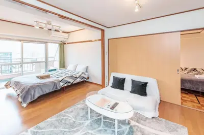 a bedroom with a bed and a couch and a table at \u56db\u8c37\u677e\u672c\u9928\u30d3\u30eb in Tokyo