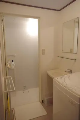 a white bathroom with a sink and a mirror at \u56db\u8c37\u677e\u672c\u9928\u30d3\u30eb in Tokyo