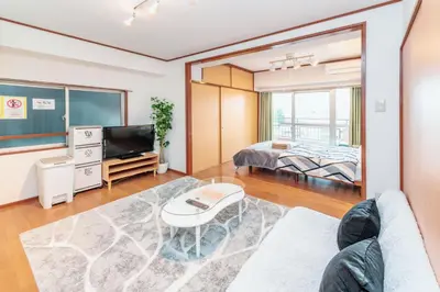 a living room with a couch and a tv and a bed at \u56db\u8c37\u677e\u672c\u9928\u30d3\u30eb in Tokyo