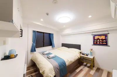a bedroom with a bed and a window at High Five Guest House in Tokyo