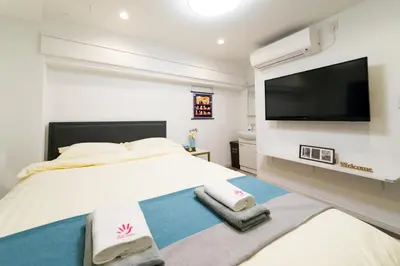 a bedroom with a large bed with a flat screen tv at High Five Guest House in Tokyo
