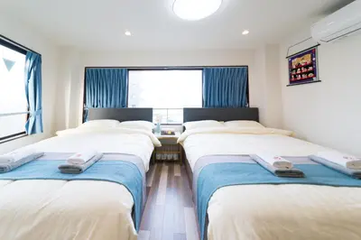 a row of beds in a room with a window at High Five Guest House in Tokyo