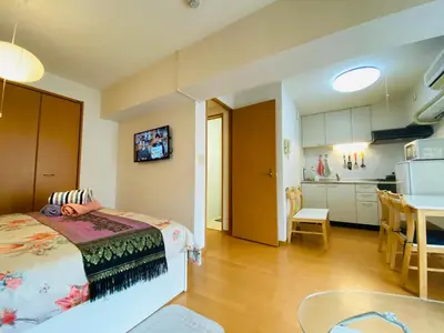 a bedroom with a bed and a kitchen with a table at Suny402-SJ0007 in Tokyo