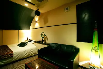a bedroom with a bed and a couch and a chair at HOTEL CHECK INN BALI adult only in Tokyo