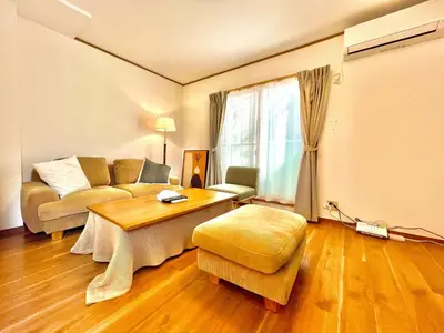 a living room with a couch and a table at \u4e0a\u843d\u5408\u30cf\u30a6\u30b9 KAMIOCHIAI HOUSE in Tokyo