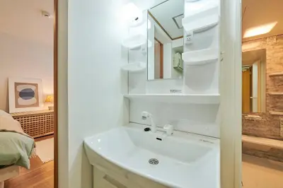 a bathroom with a white sink and a mirror at \u4e0a\u843d\u5408\u30cf\u30a6\u30b9 KAMIOCHIAI HOUSE in Tokyo